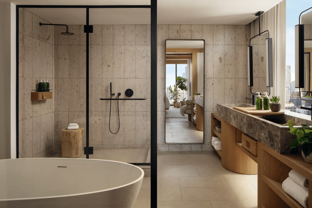 Salle de bain d'une suite du 1 Hotel Austin, baignoire et douche en pierre