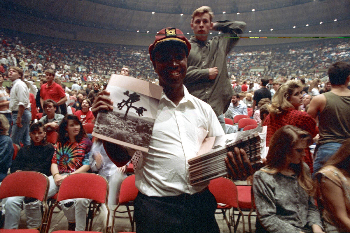 A fan is seen holding programs with The Joshua Tree album cover art at the U2 concert held at the Tarrant County Convention Center on Nov. 23, 1987.