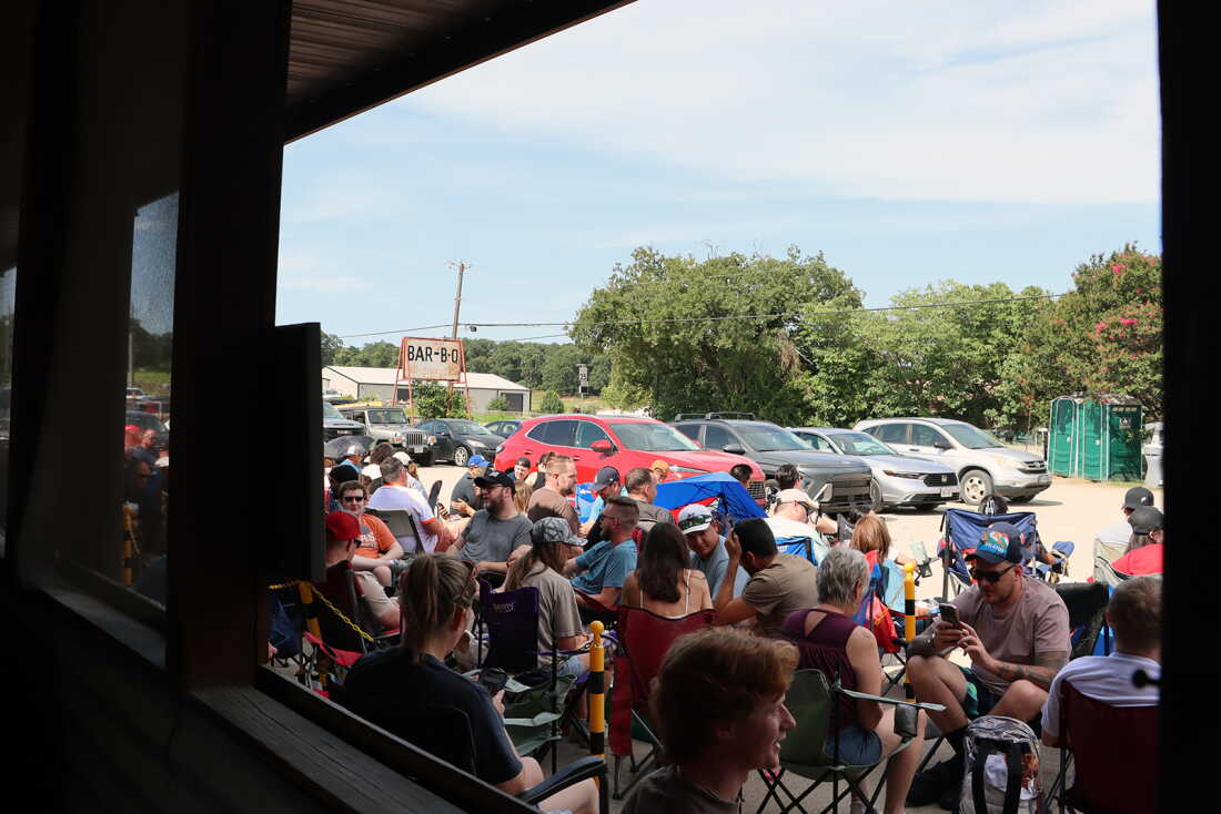 Customers sit in lawn chairs waiting for Goldee’s BBQ to open on a summer Saturday in Fort Worth, Texas. (RNS photo/Fiona André)