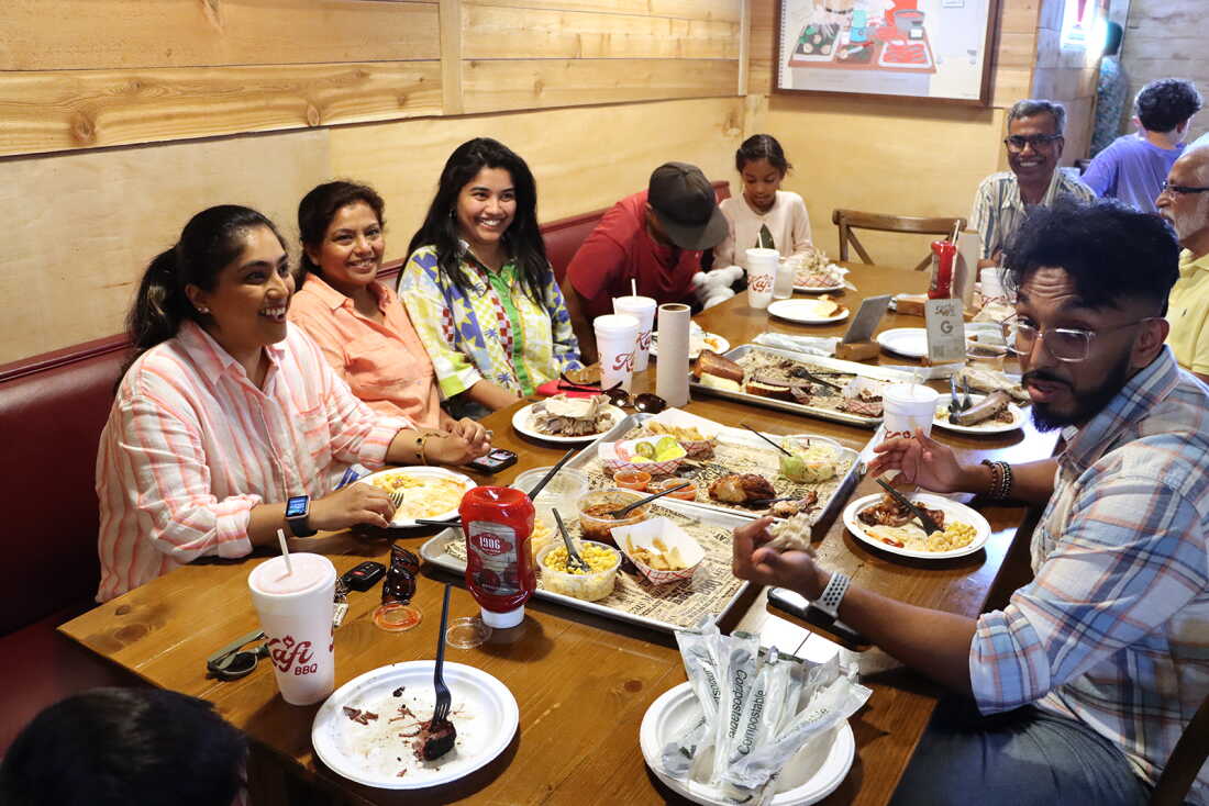 Areeba Ali, third from left, eats at Kafi BBQ, with family, in Irving, Texas.