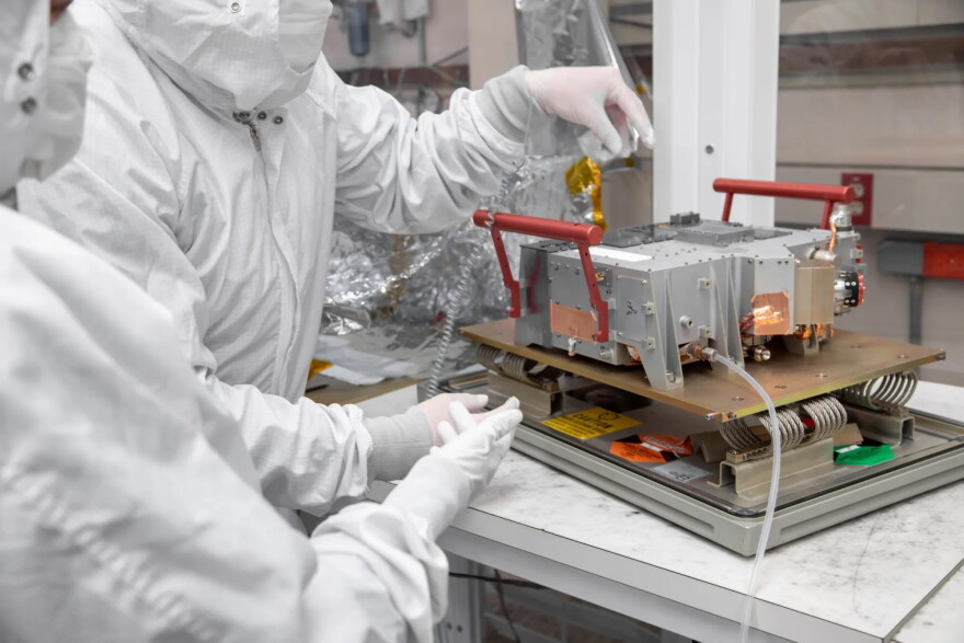 Southwest Research Institute scientists Tracy Becker and Kurt Retherford are pictured in 2022 with one of the SwRI-built instruments on board NASA’s Europa Clipper spacecraft.