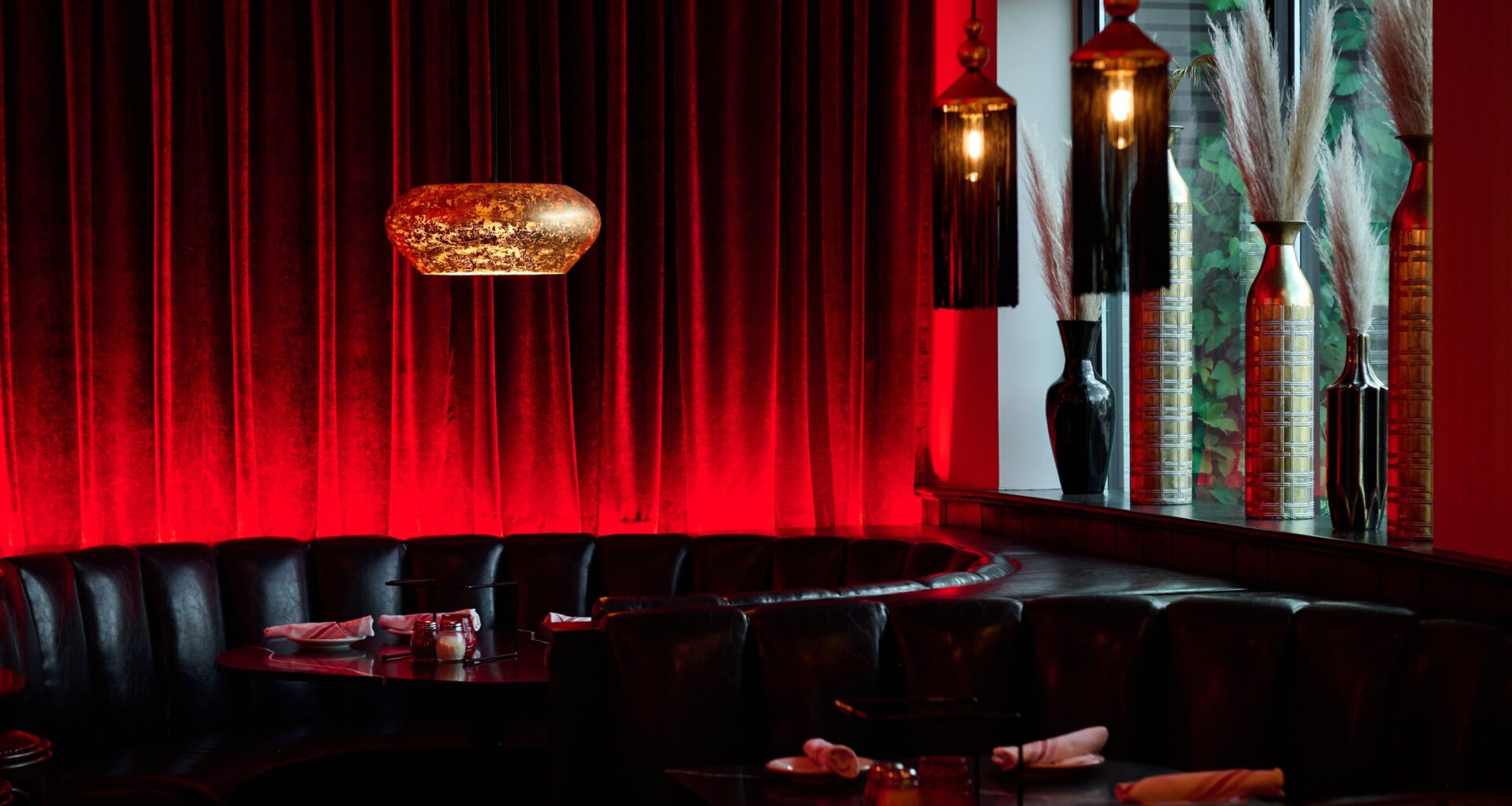 An empty booth with a red curtain behind it.