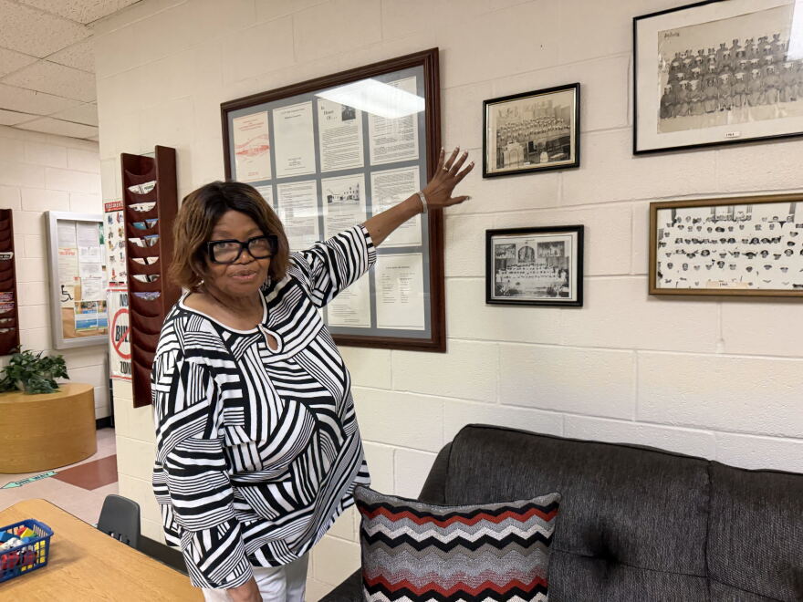 Director Gwendolyn Sneed points to photographs of the early graduating classes at Good Street Learning Center in South Dallas.