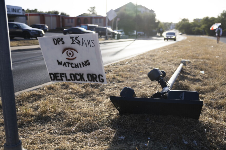 A downed Flock camera lays in front of a Kind Clinic, a place that provides gender-affirming care, near North Lamar Boulevard on August 19, 2026, in Austin, Texas. Lorianne Willett/KUT News