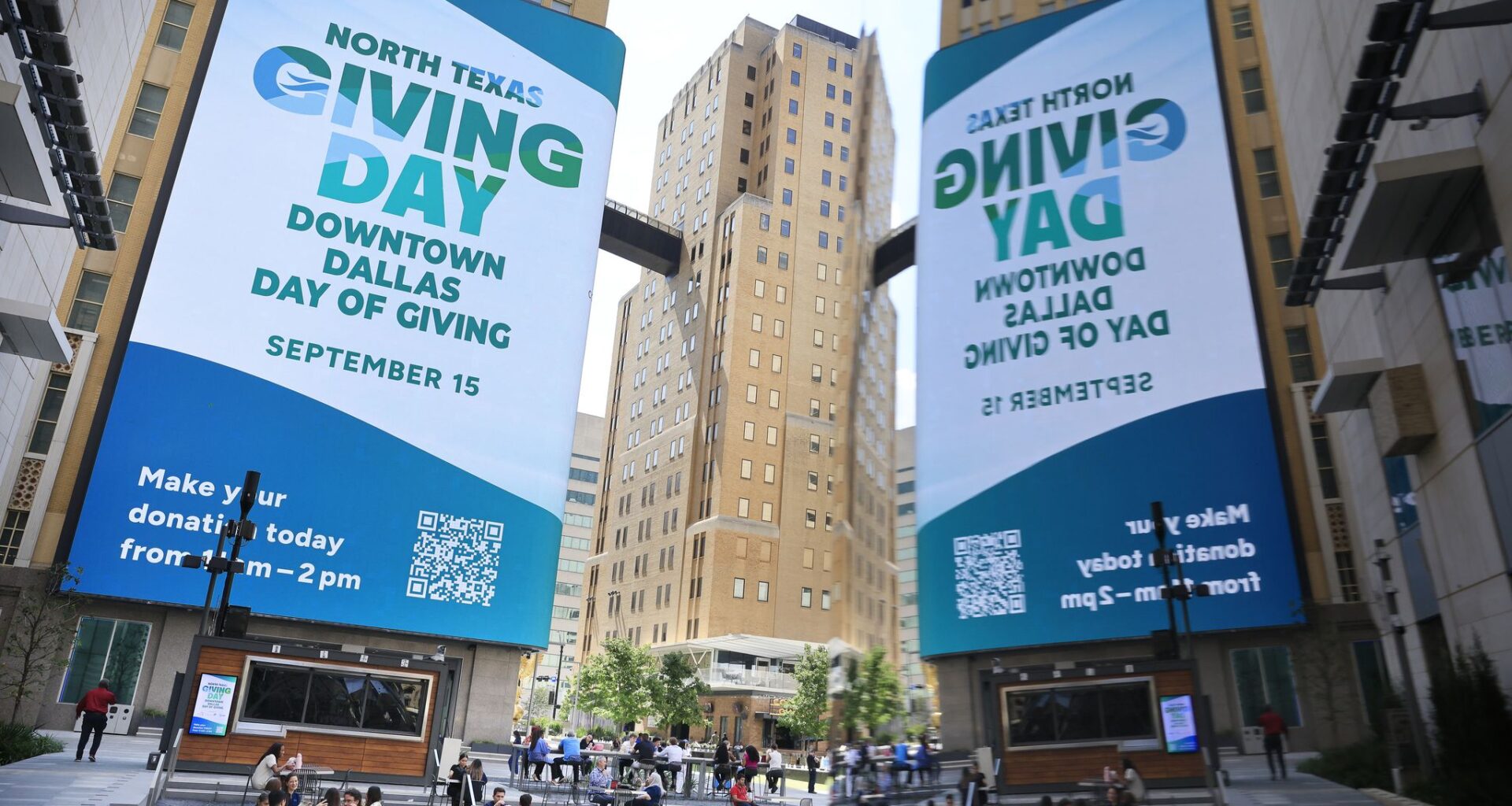 Downtown Dallas Inc. kicked off North Texas Giving Day at the AT&T Discovery District In downtown Dallas, September 15, 2025. The video board is reflected in a plaza sculpture.