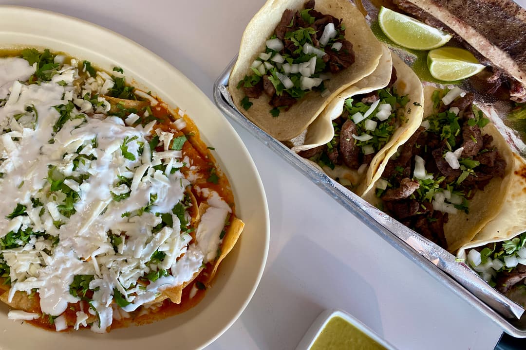 The photo shows an ariel view of a table with the rib-eye tacos and chilaquiles.