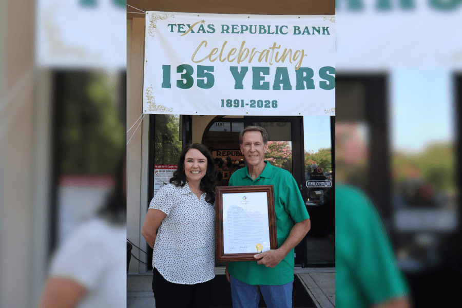 Two people hold a framed certificate beneath a banner reading Texas Republic Bank Celebrating 135 Years 1891-2026.