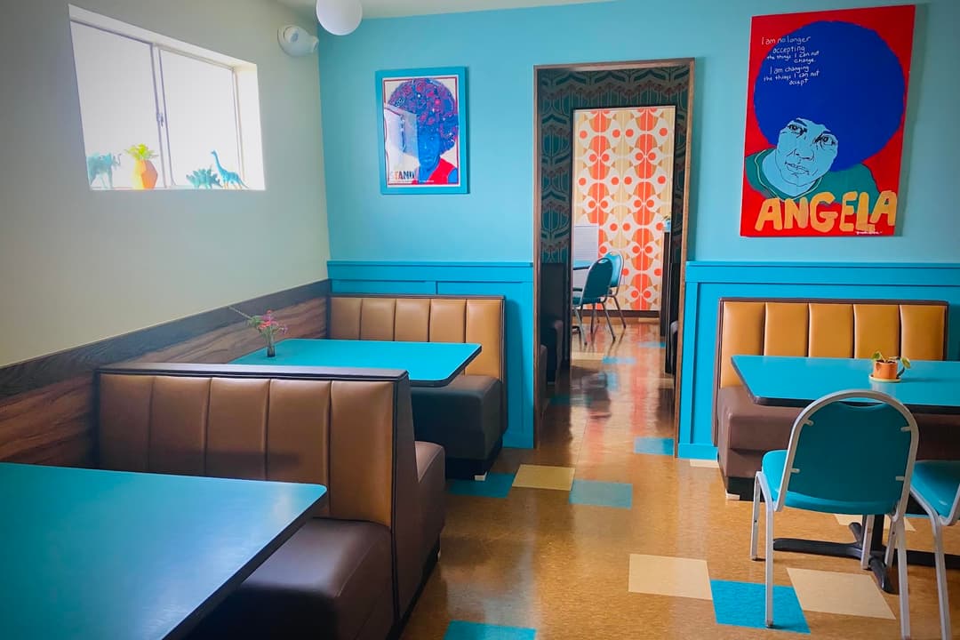 Interior of the booth with bright blue walls and brown vynil booths.