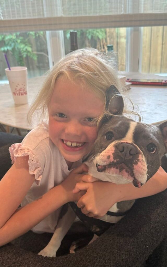 Eloise “Lulu” Peck with her grandparent's dog Henry in a toy Porsche. Lulu was named the ASPCA’s 2026 Kid of the Year. The honor will be accepted posthumously after her death at age 8 in the July 2025 flooding near Camp Mystic.