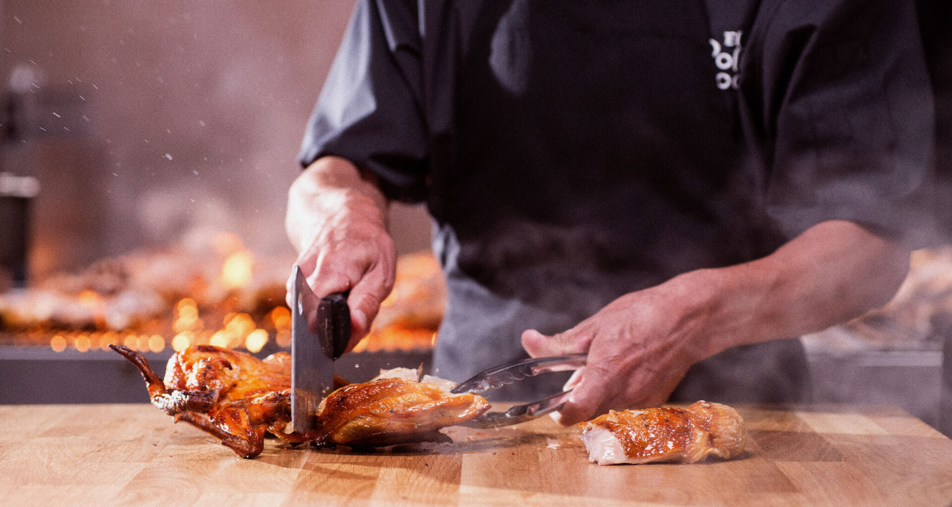 An El Pollo Loco grill master is seen chopping pieces of fire-grilled chicken.