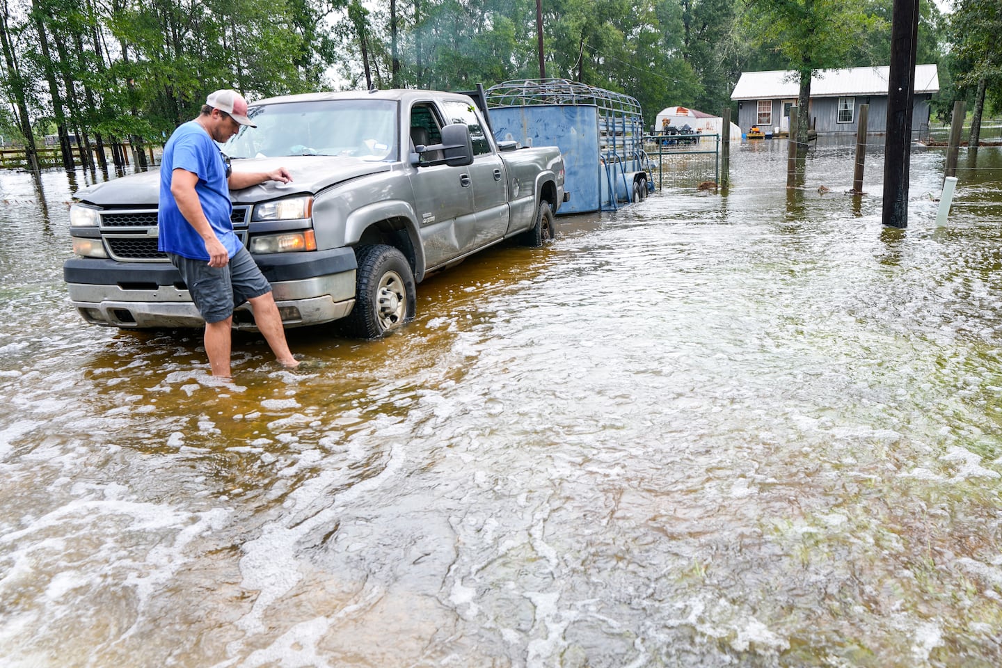 Chase Barfield walks to his truck as he takes belongings and his dogs away from floodwaters around his house in the aftermath of Tropical Storm Edouard near Honey Island, Texas, on Sept. 2, 2026.