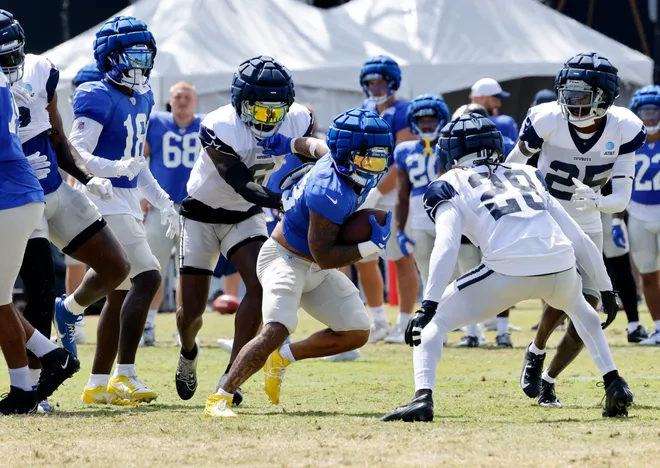 OXNARD, CALIFORNIA - AUGUST 8: Running back Kyren Williams #23 of the Los Angeles Rams rushes against safety Malik Hooker #28 and Donovan Wilson #6 of the Dallas Cowboys during joint practice at training camp on August 8, 2024 in Oxnard, California. (Photo by Kevork Djansezian/Getty Images)