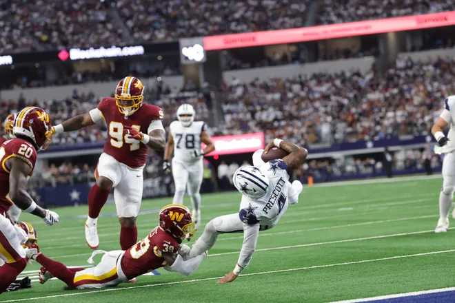 Sep 20, 2026; Arlington, Texas, USA; Dallas Cowboys quarterback Dak Prescott (4) is tackled after running the ball against Washington Commanders safety Jeremy Reaves (39) and defensive tackle Daron Payne (94) during the first quarter at AT & T Stadium. Mandatory Credit: Kevin Jairaj-Imagn Images