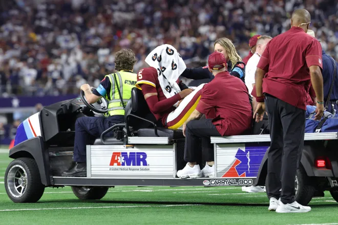 Sep 20, 2026; Arlington, Texas, USA; Washington Commanders quarterback Jayden Daniels (5) is carted off the field with an apparent injury to his left arm during the second half against the Washington Commanders at AT & T Stadium. Mandatory Credit: Kevin Jairaj-Imagn Images