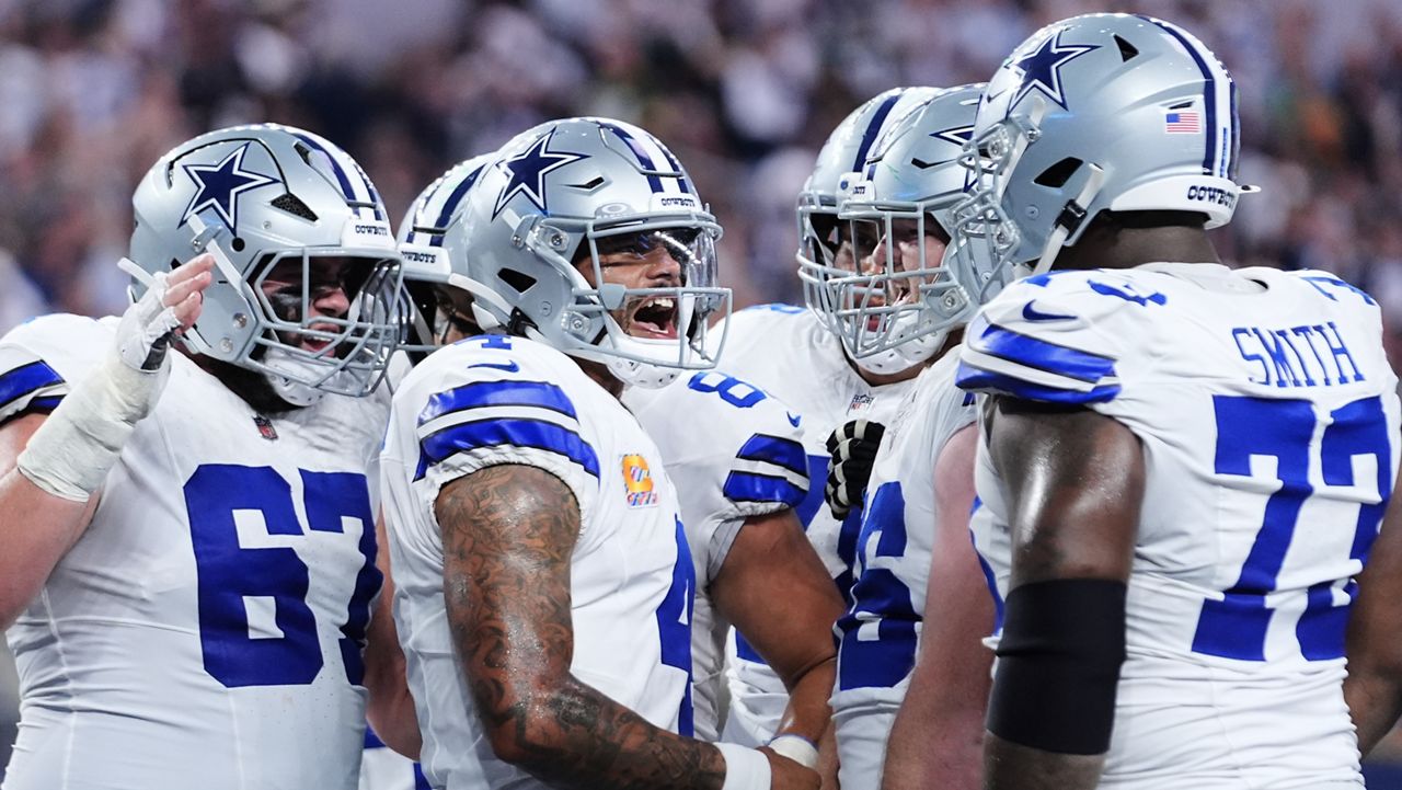 Dallas Cowboys' Dak Prescott, second from left, celebrates with Brock Hoffman (67), Tyler Smith (73) and others after running the ball for a touchdown in the first half of an NFL football game against the Green Bay Packers Sunday, Sept. 28, 2025, in Arlington, Texas. (AP Photo/Julio Cortez)