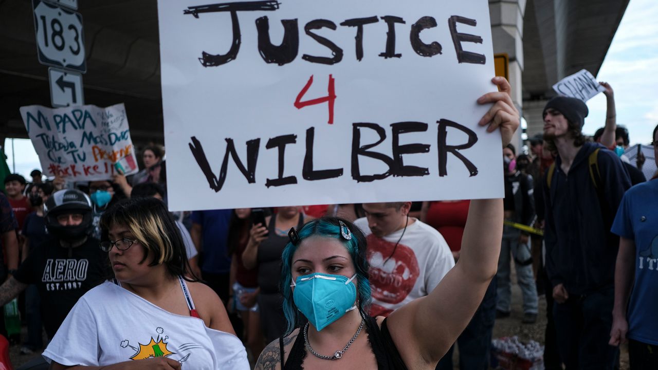 People speak during a demonstration where a man was shot in his vehicle by an ICE officer, Sunday, Sept. 20, 2026, in Austin, Texas. (AP Photo/Joel Angel Juarez)