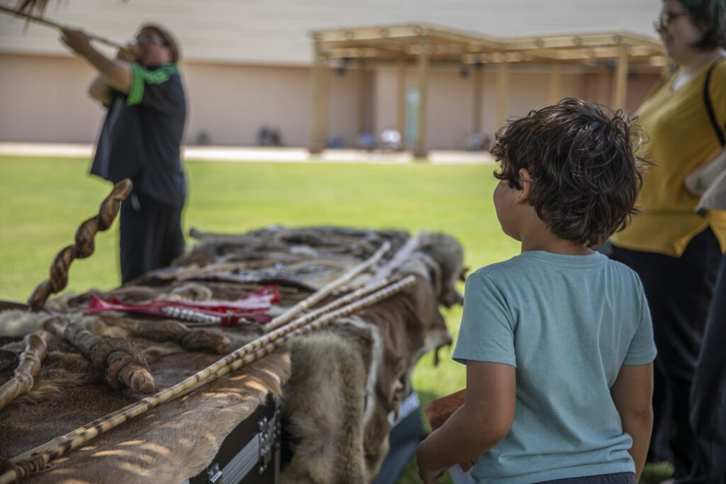 Children watching a cultural demonstration at a fall festival in Oklahoma