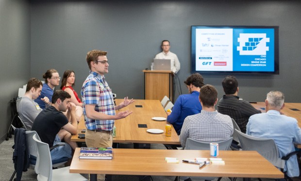 Gary Scott, left, and Sean Hemenway, both co-lead competition organizers, give a presentation during a design competition for single stair apartment buildings held at the GFT offices at Prudential Plaza in Chicago's Loop on June 23, 2026. The competition is set to allow participants to design single stair buildings for review by a panel of judges at the end of the summer. (Josh Boland/Chicago Tribune)