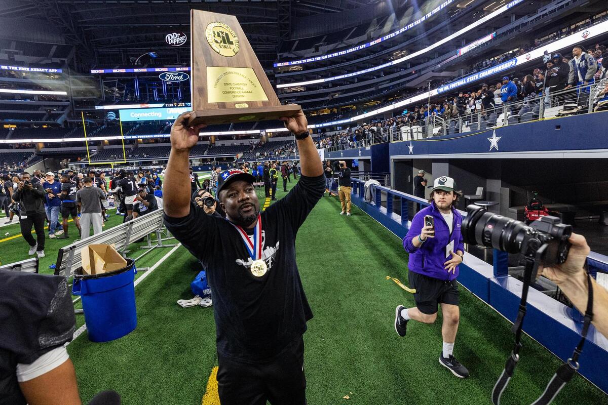 North Crowley Head Coach Ray Gates hoists the championship trophy after winning the UIL 6A Division I state championship game against Austin Westlake at AT&T Stadium in Arlington on Saturday, Dec. 21, 2024.
