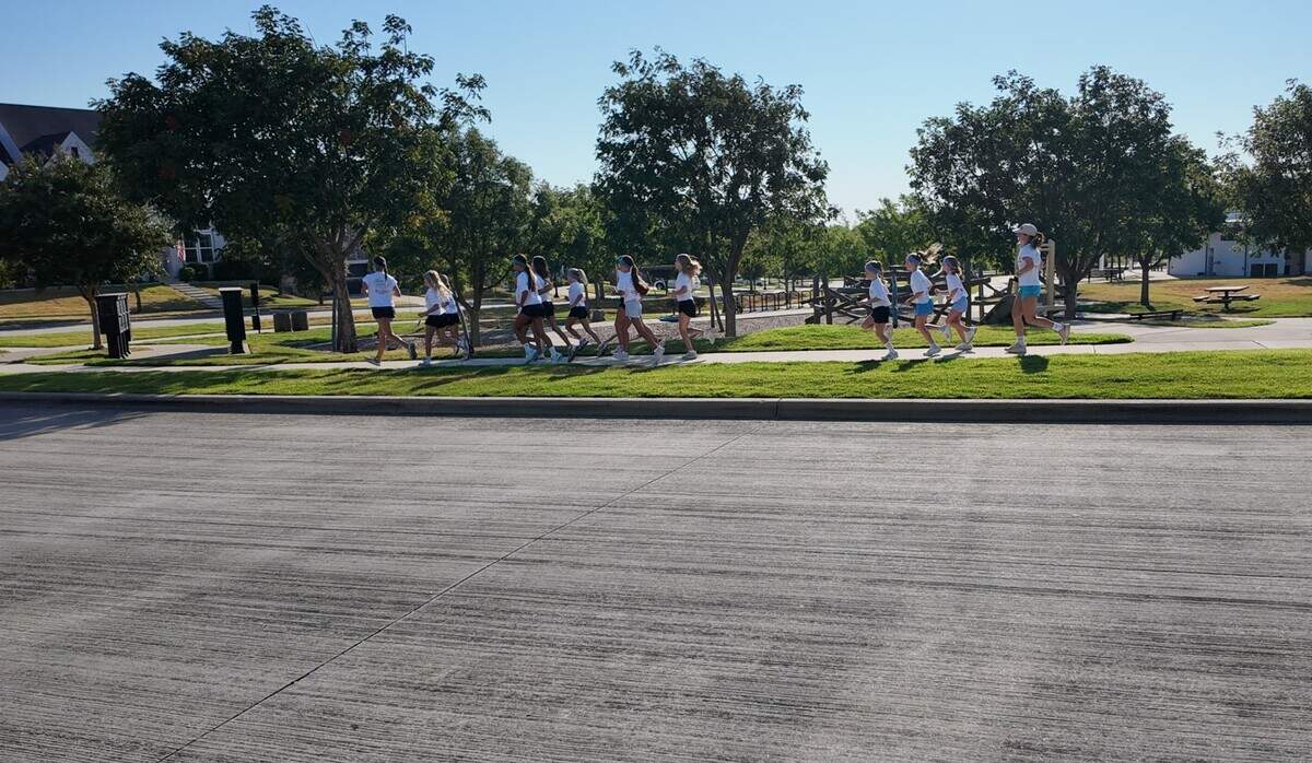 Aledo High School students, Haddi and Mac Richardson, mentor the younger girls through stretches, the mile long run and a devotional at Faith in Motion run club on Aug. 29, 2026 in Aledo.