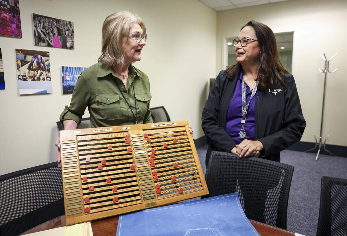Andra Bennett, Public Events Communications Coordinator, and Gina Castillo, Field Operations Supervisor, look at an old time off calendar that was used by the Fort Worth Convention Center staff, on Friday, Aug. 21, 2026 in Fort Worth.