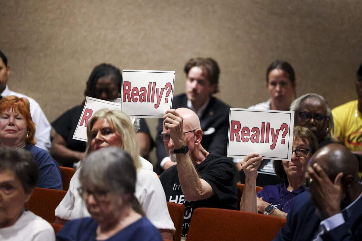 Community members hold up signs opposing the proposed cuts of voting sites on Tuesday, Sept. 1, 2026 in Fort Worth.