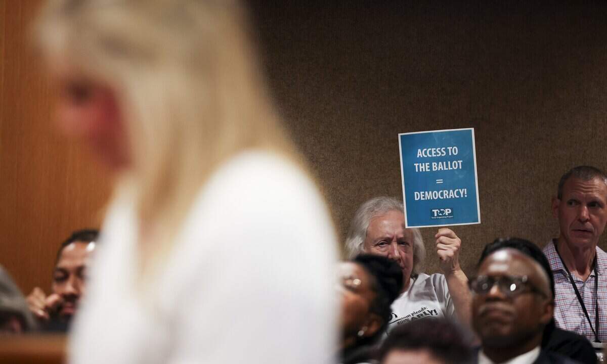A community member holds up a sign opposing the proposed cuts of voting sites on Tuesday, Sept. 1, 2026 in Fort Worth.