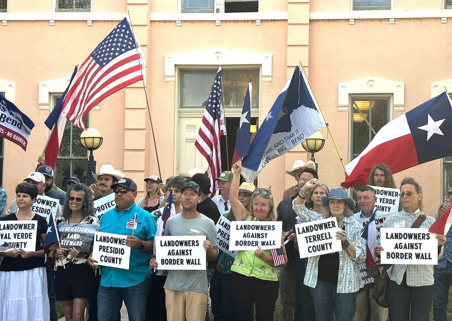 Landowners and other supporters held signs against the Trump administration's plans to build a border wall and other infrastructure in Texas' remote Big Bend region, Monday, in Marfa, Texas.