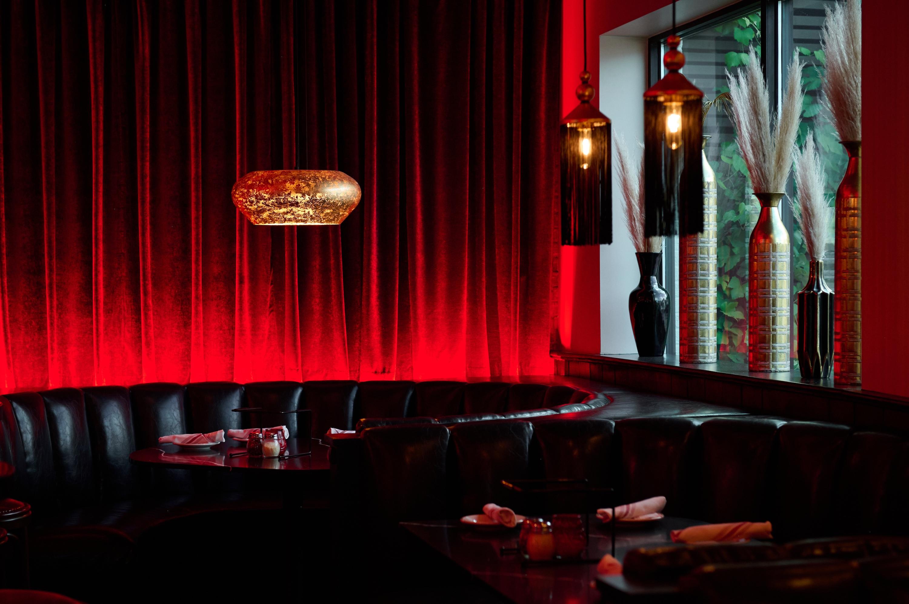 An empty booth with a red curtain behind it.