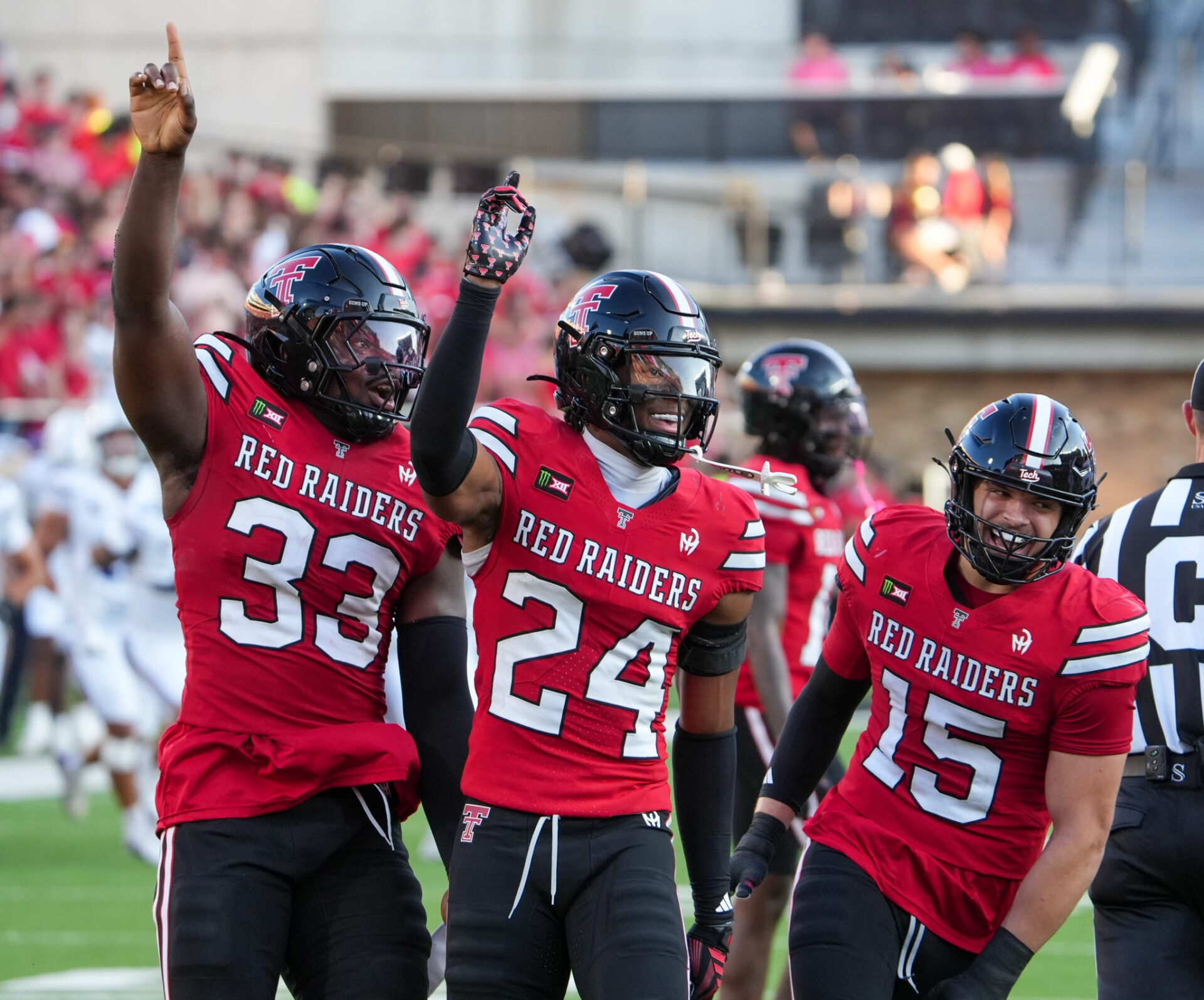 Texas Tech defenders Ansel Nedore (33), Malik Esquerra (24) and Austin Romaine react to a stop against Abilene Christian during