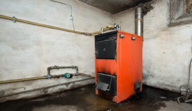 An orange heating boiler is positioned against a bare wall with visible pipes and a damp floor.
