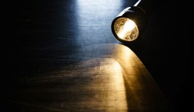 A lit flashlight on a wooden table.