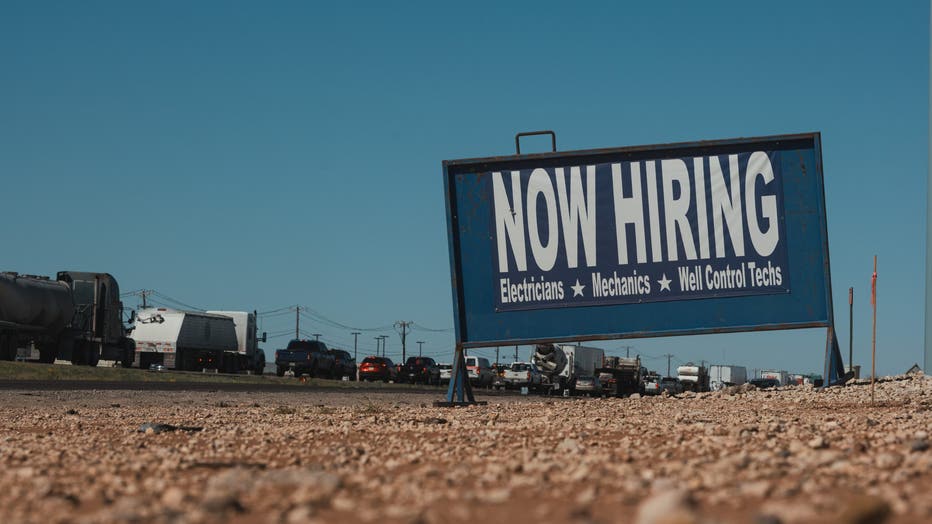 A "Now Hiring" sign along the highway in Midland, Texas, US, on Thursday, April 27, 2023.