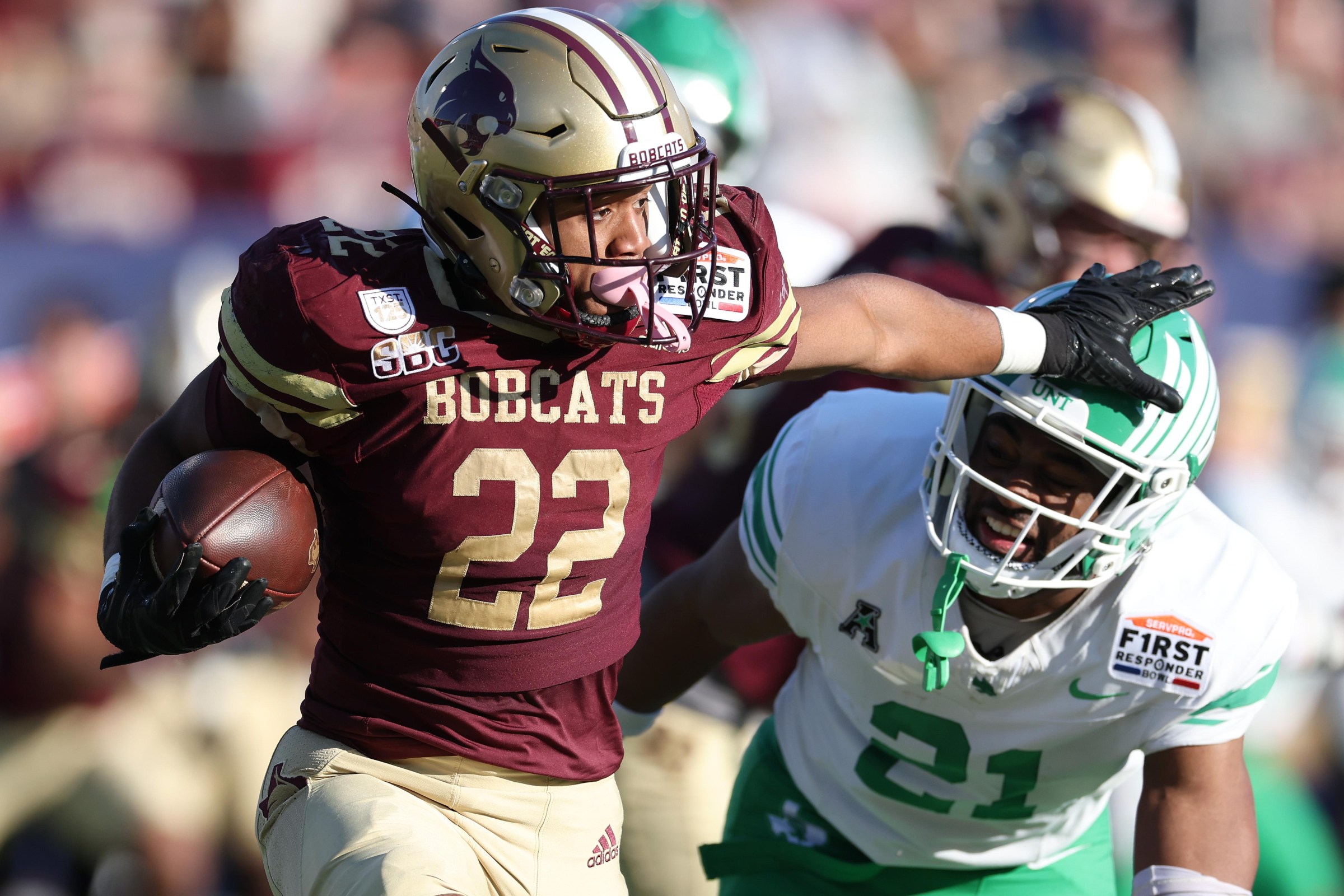 DALLAS, TEXAS - JANUARY 03: Torrance Burgess Jr. #22 of the Texas State Bobcats runs with the ball past Jayden Hill #21 of the North Texas Mean Green during the first half of the SERVPRO First Responder Bowl at Gerald J. Ford Stadium on January 03, 2025 in Dallas, Texas. (Photo by Sam Hodde/Getty Images)