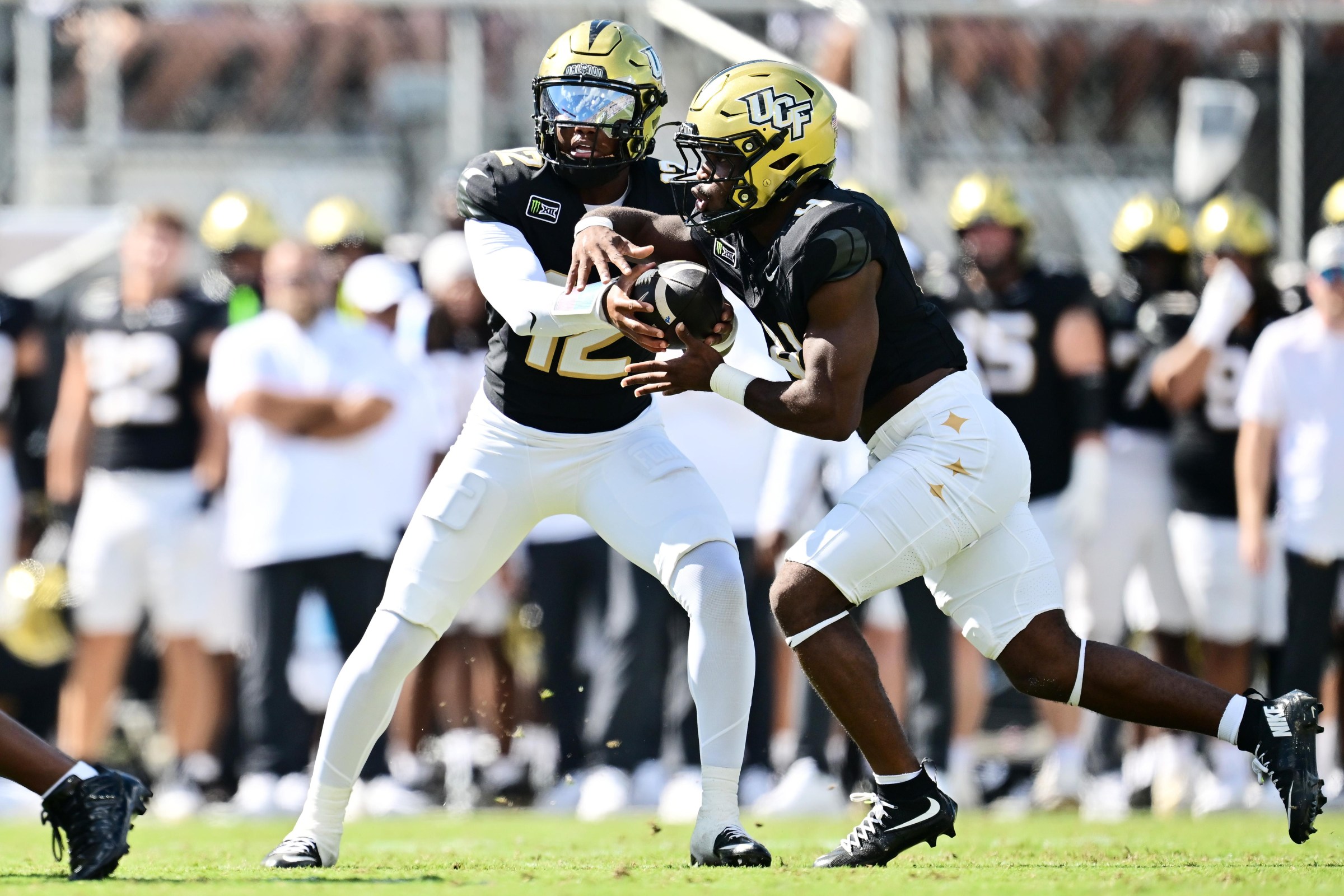 ORLANDO, FLORIDA - SEPTEMBER 26: Keyone Jenkins #12 of the UCF Knights hands the ball off to Taevion Swint #4 in the first half of a game against the TCU Horned Frogs at Acrisure Bounce House on September 26, 2026 in Orlando, Florida. (Photo by Julio Aguilar/Getty Images)