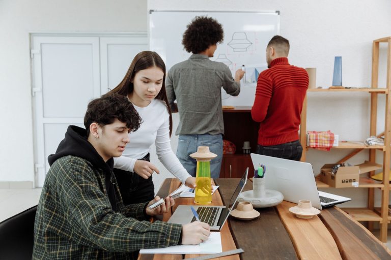 People reviewing product designs at a table and whiteboard