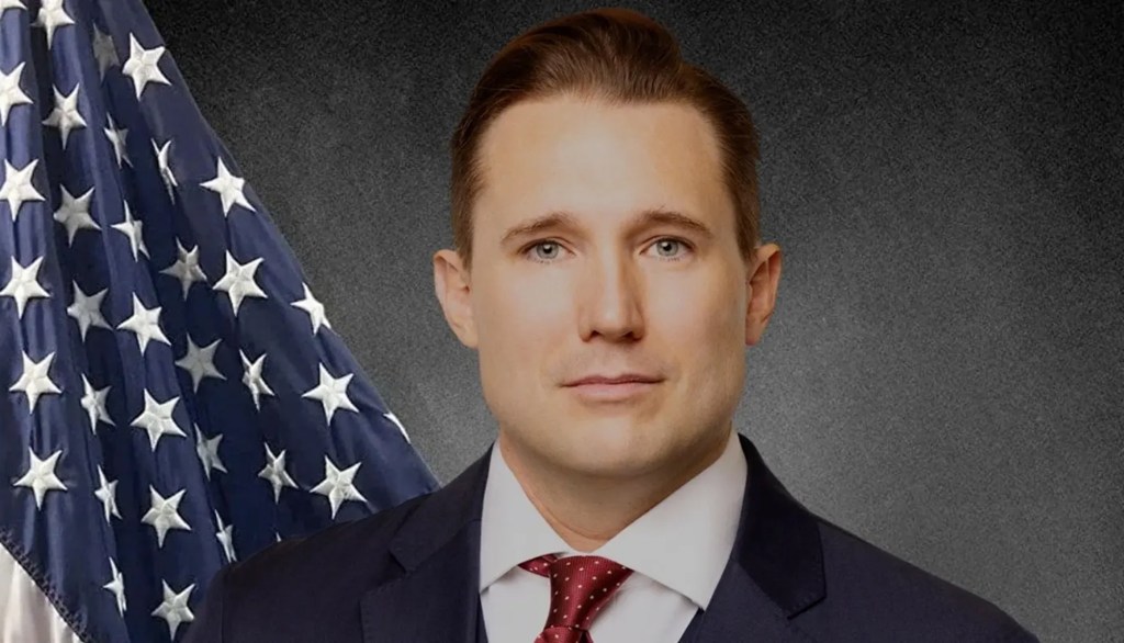 Timothy M. Good against an American flag.