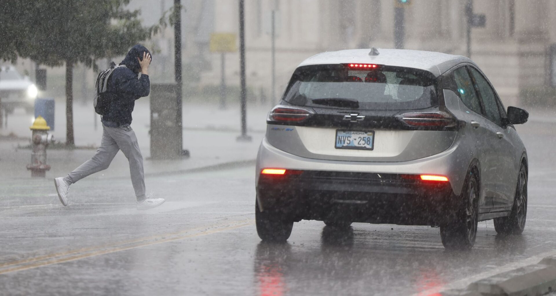A man runs across South Harwood Street as heavy rain falls, Wednesday, Sept. 30, 2026, in downtown Dallas.