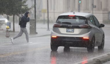 A man runs across South Harwood Street as heavy rain falls, Wednesday, Sept. 30, 2026, in downtown Dallas.
