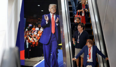 Republican midterm convention attendees take an escalator down past a large photo of President Donald Trump on Sept. 10 in the American Airlines Center.