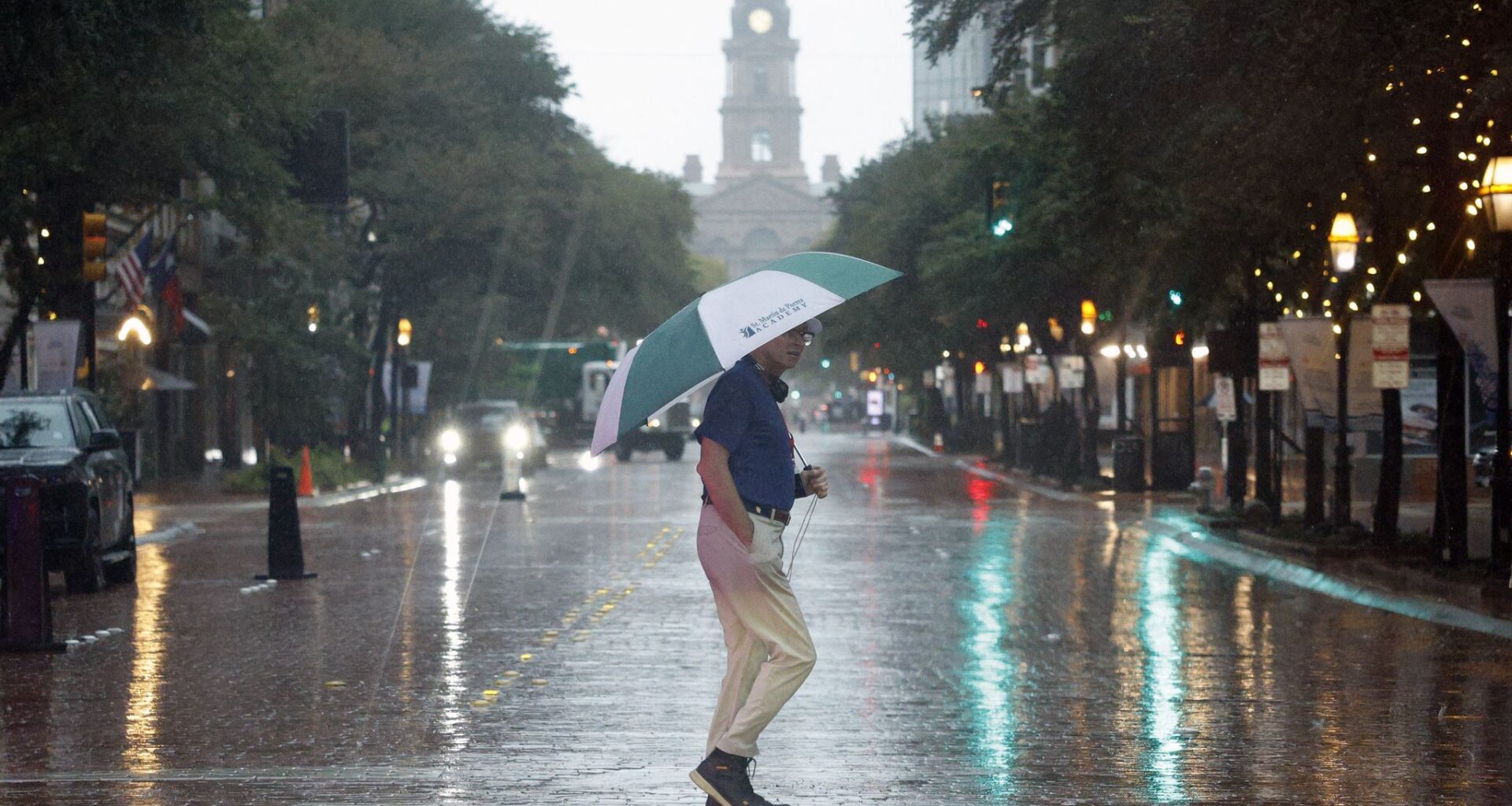 A man crosses Main Street with an umbrella in downtown Fort Worth on Thursday, Oct. 1, 2026.