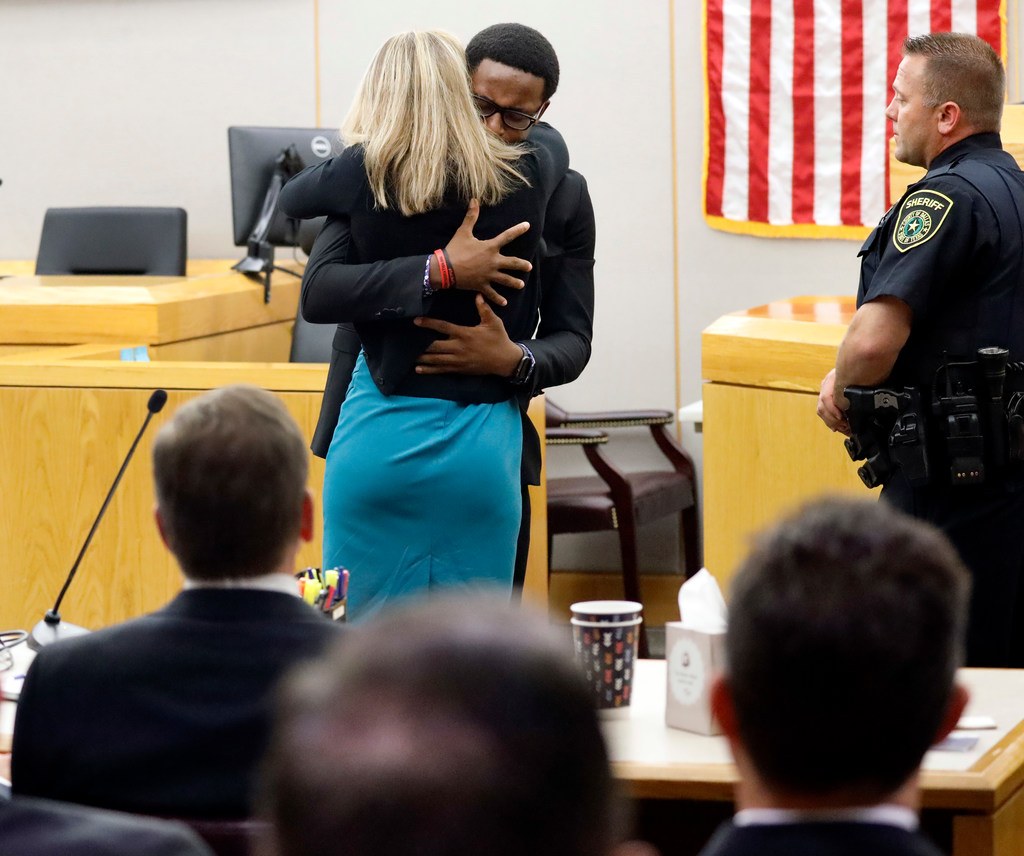 Botham Jean's younger brother Brandt Jean hugs former Dallas officer Amber Guyger after delivering his impact statement to her following her 10-year prison sentence for murder.