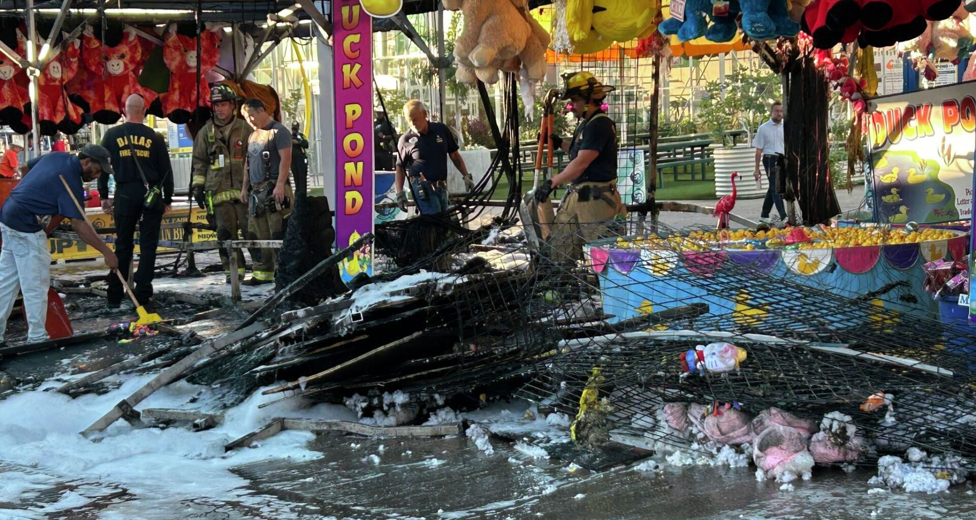 Dallas firefiighters work the scene at a midway game at the Texas State Fair Monday morning following a fire.