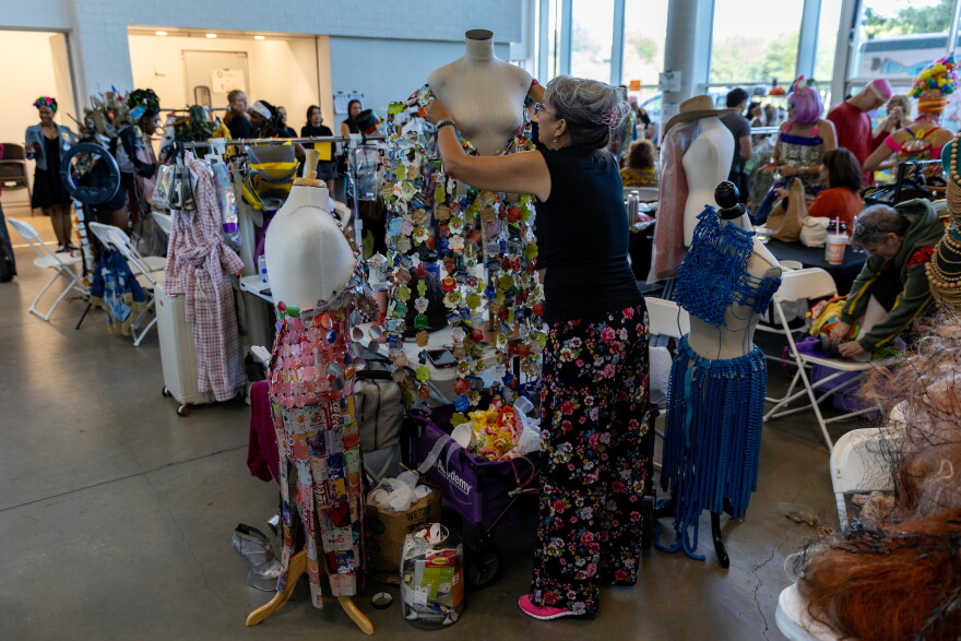 Dara Biegert Fry works on one of three designs featured in the “Reuse on the Runway 2026” show backstage in Austin, Texas, on Oct. 17, 2026. Joe Ferrara / KUT News