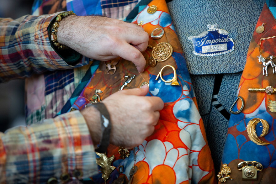 Max Wallace affixes a button to his design, “Tart in Tartan,” backstage at the Austin Creative Reuse “Reuse on the Runway 2026” show in Austin, Texas, on Oct. 17, 2026. Joe Ferrara / KUT News