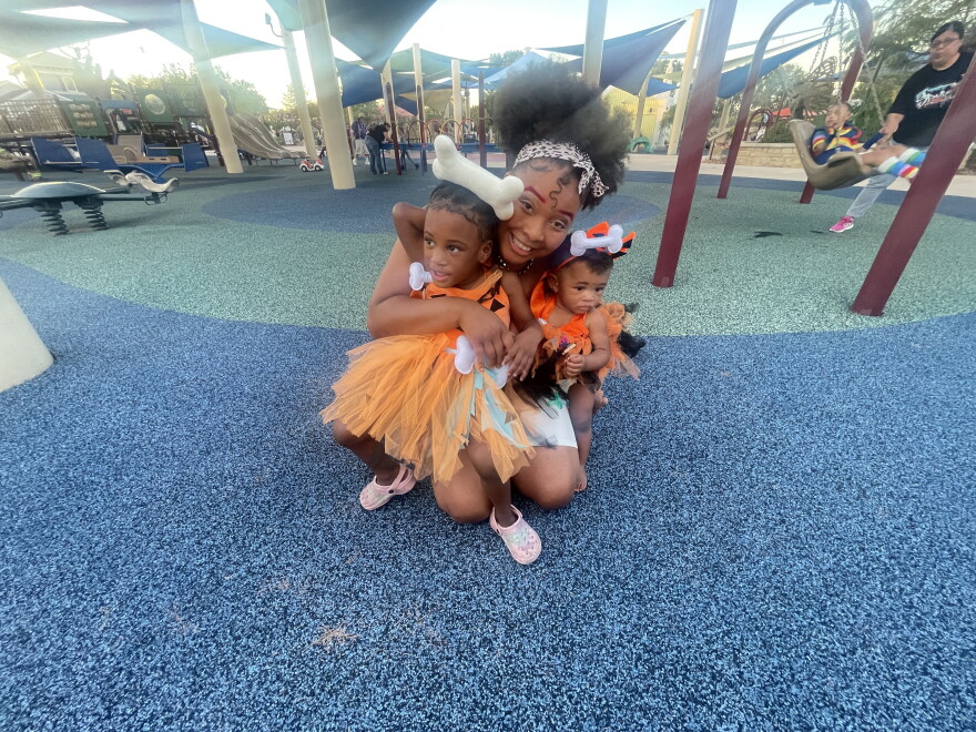 A mother and two children enjoying Fall Fest, an annual Halloween celebration organized by University Health for children who have participated in its programs that support premature infants and children with medical and developmental needs