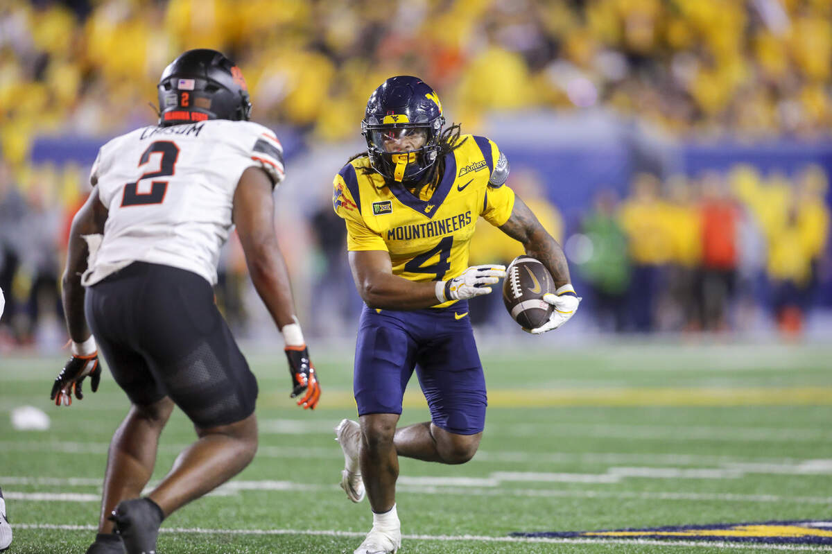 West Virginia running back Cam Cook (right) carries during the fourth quarter against Oklahoma State on Sept. 26, 2026, at Milan Puskar Stadium in Morgantown, W.Va.