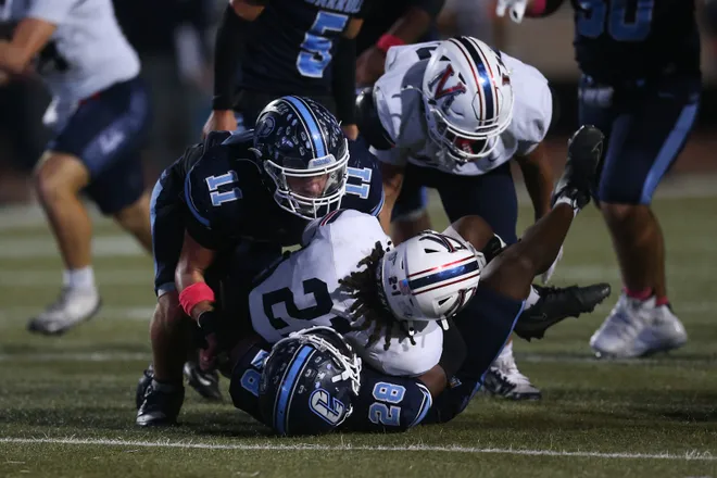 Carroll's Aiden Ben-Davd and Antoneo Johnson combine to make a stop on Veterans Memorial's Zhi'Yeair Lofton during a district football game at Buccaneer Stadium on Friday, Oct. 9, 2026.