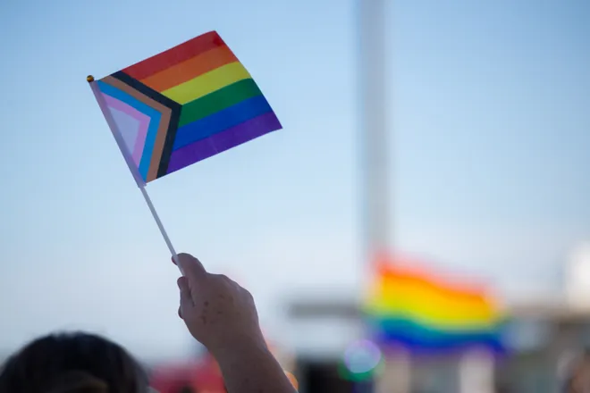 A crowd member waves an LGBTQ+ flag at the Pride Parade and Block Party hosted by Pride Corpus Christi at Water's Edge Park in Corpus Christi, Texas, on Oct. 10, 2026.