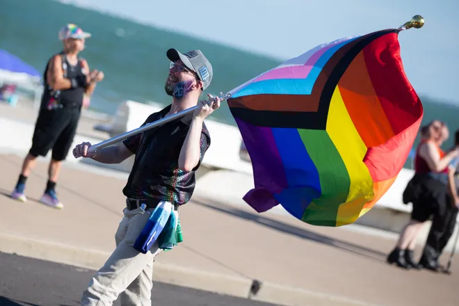 A marcher waves an LGBTQ+ flag at the Pride Parade and Block Party hosted by Pride Corpus Christi at Water's Edge Park in Corpus Christi, Texas, on Oct. 10, 2026.